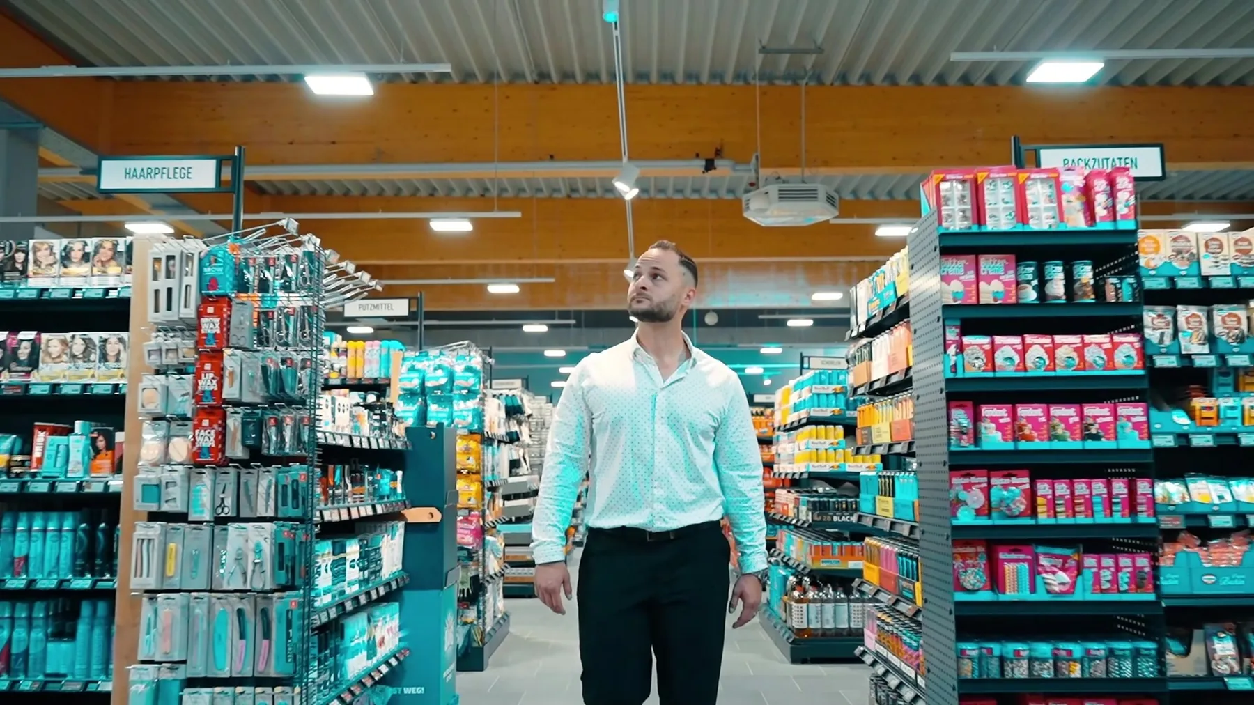 Marcus Strube, Geschäftsführer von SIGMA, geht durch den Gang eines eingerichteten Supermarkts.