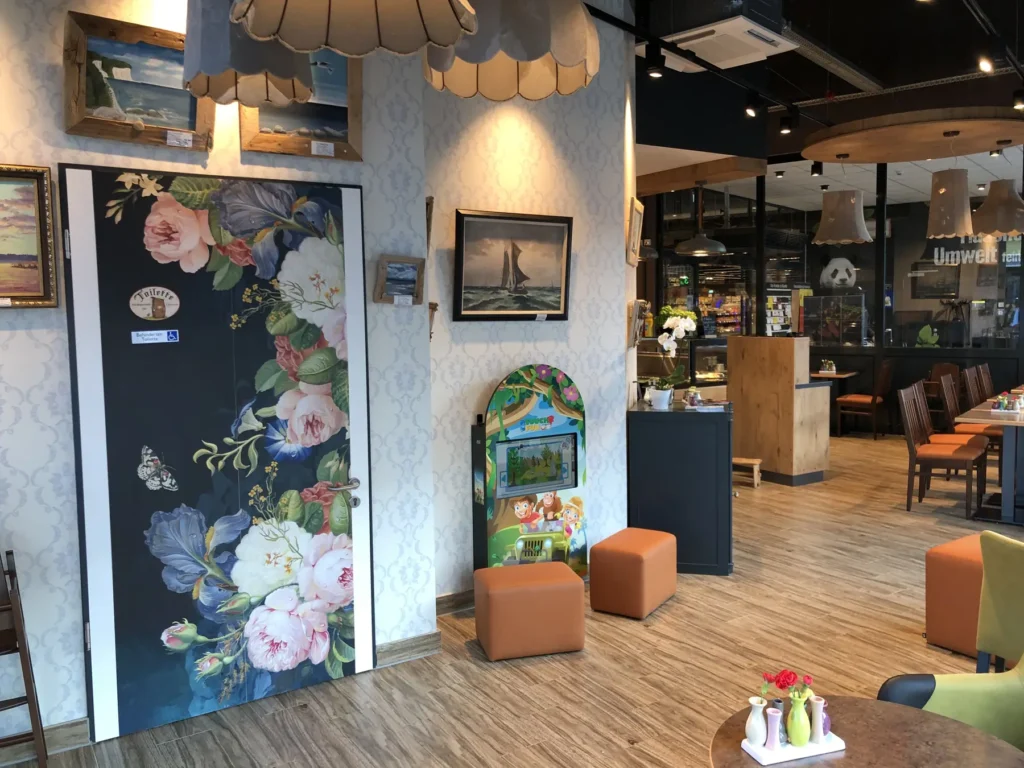 Gastbereich mit floraler Wandgestaltung und Sitzhockern