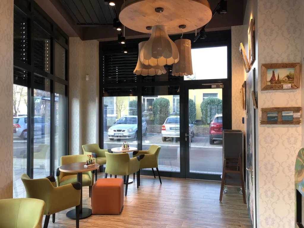 Café-Bereich mit farbigen Sesseln und Blick zur Straße