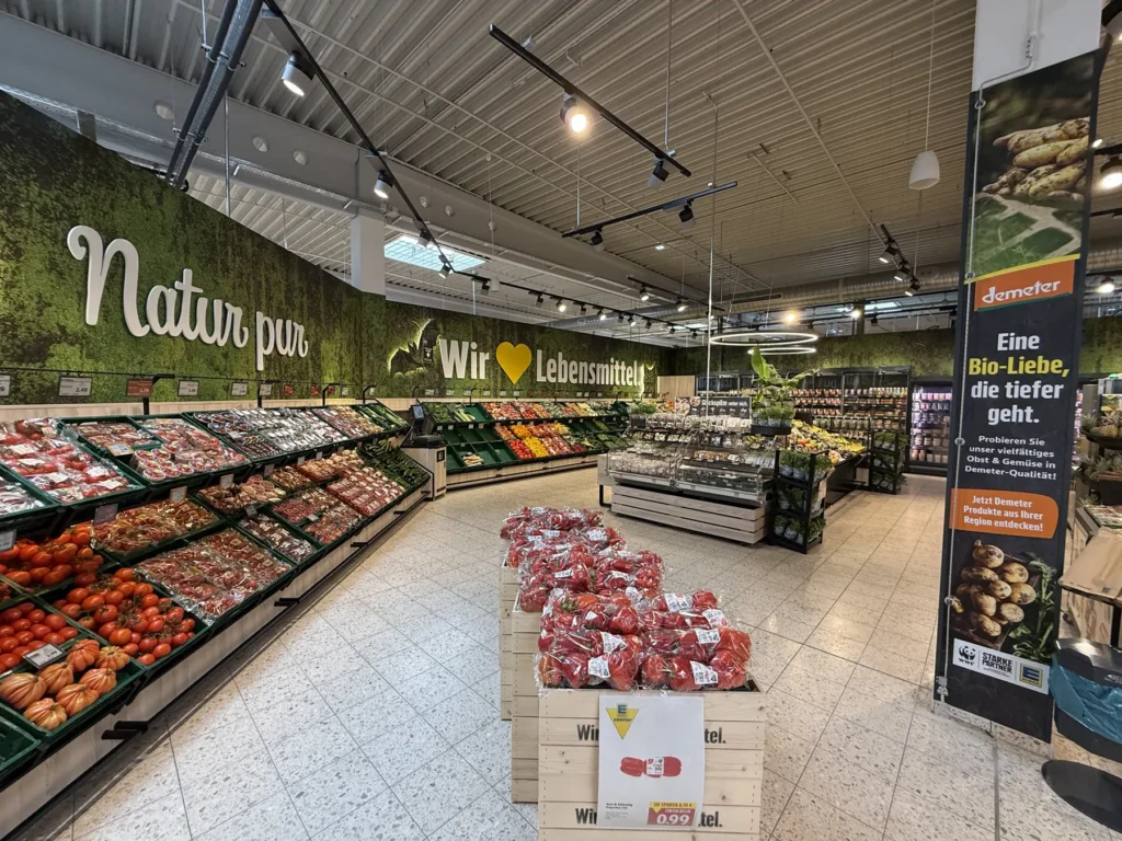 Obst- und Gemüsegang mit grüner Wandgrafik