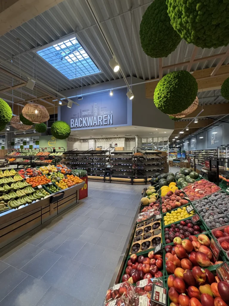 Apfelpräsentation unter hängender Kugeldekoration vor der Backwaren-Theke