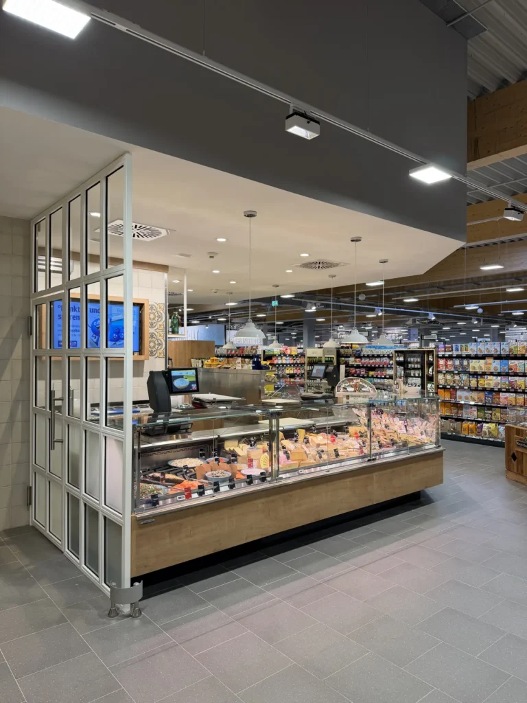 Frischetheke mit Fleisch- und Wurstsortiment hinter verglaster Trennwand