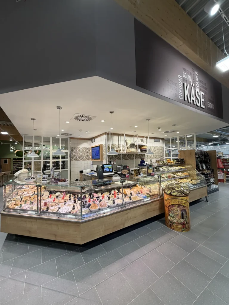 Käsetheke mit Vitrine unter dem Deckenschriftzug »Käse«