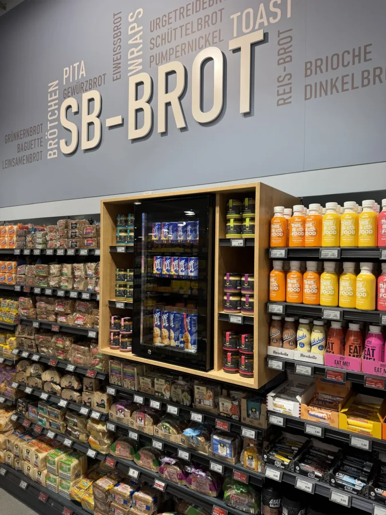 SB-Brotregal vor Wandbeschriftung mit Brot- und Gebäcksorten