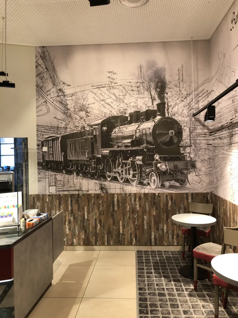 Gastbereich vor Wandbild mit historischer Dampflokomotive