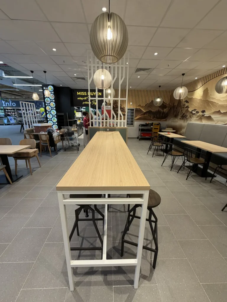Gastraum mit langem Holztisch und Wandbild