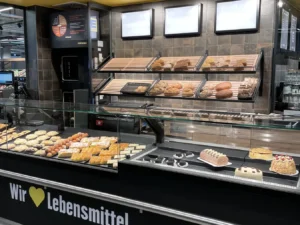 Backtheke mit Gebäckauslage und Schriftzug »Wir lieben Lebensmittel«