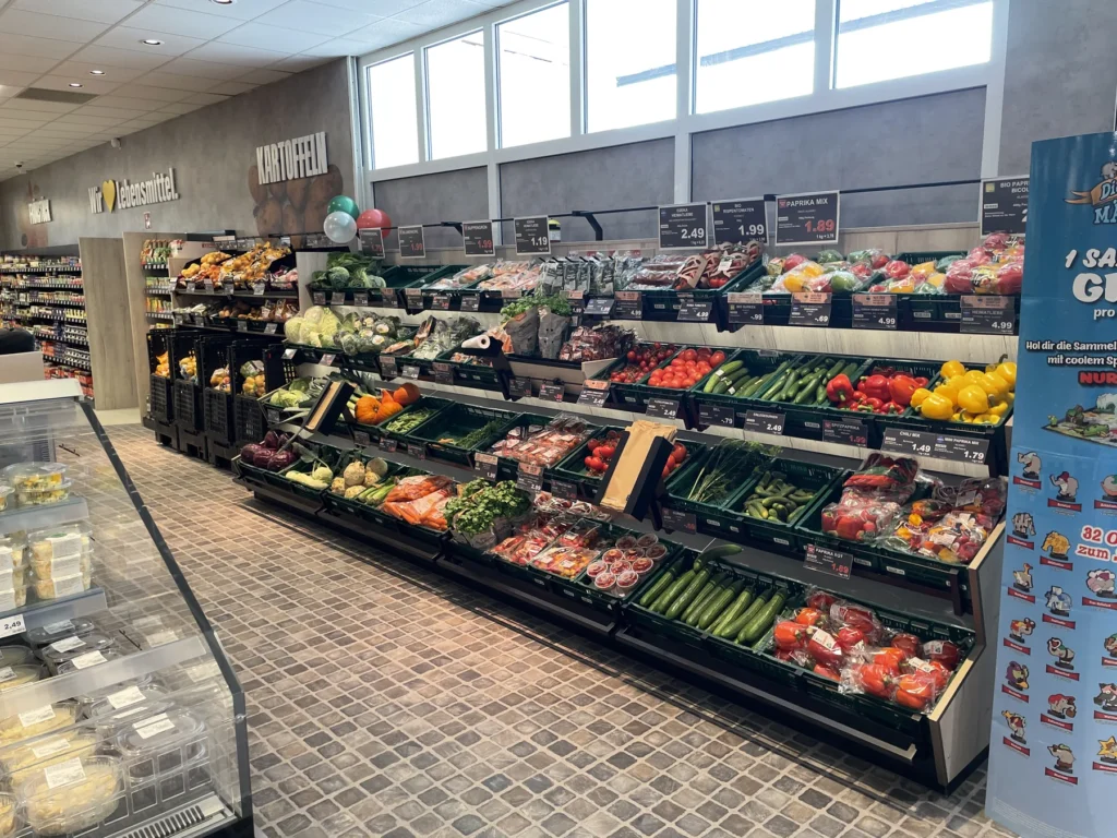 Obst- und Gemüseabteilung mit langen Regalzeilen am Fenster