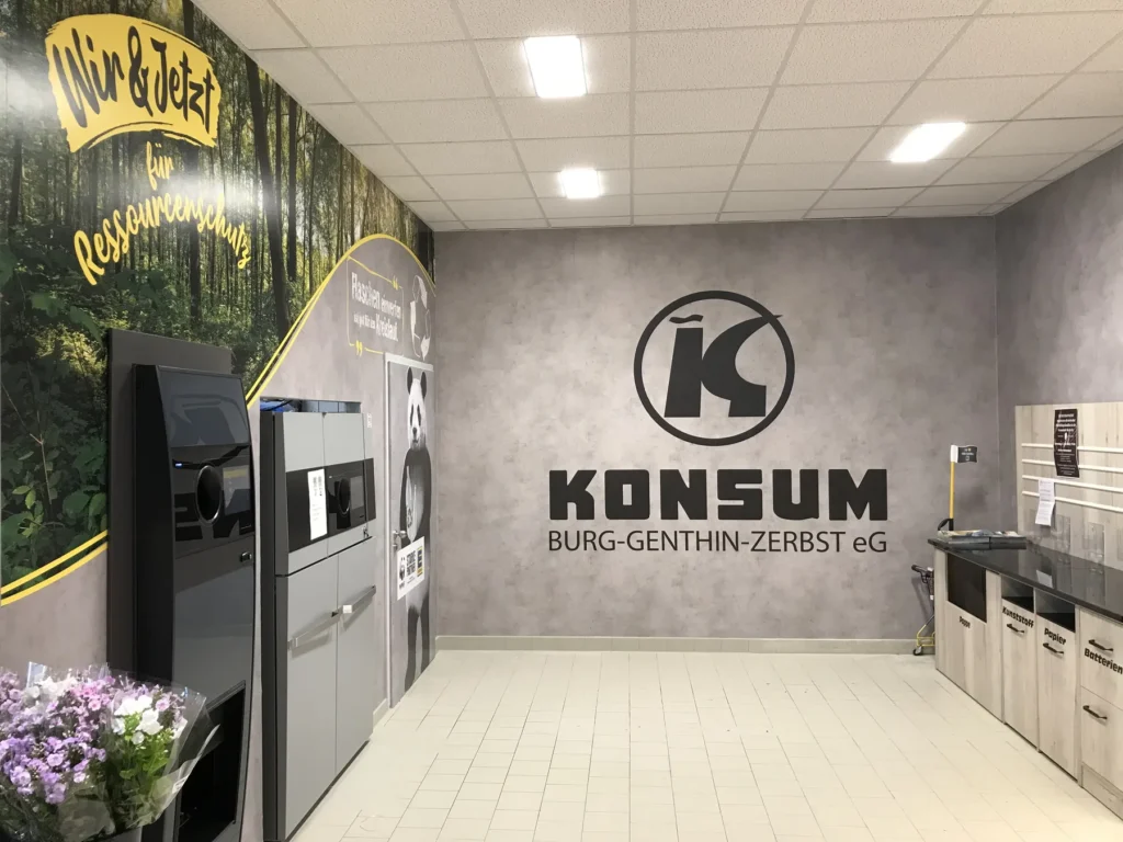 Eingangsbereich mit Wandgrafik und Logo des Betreibers