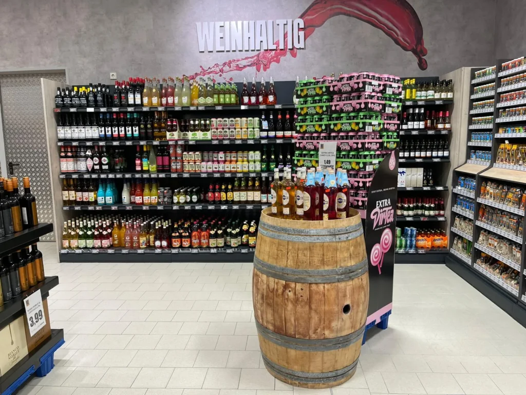 Getränkeabteilung mit Weinfass und Wandschriftzug »Weinhaltig«