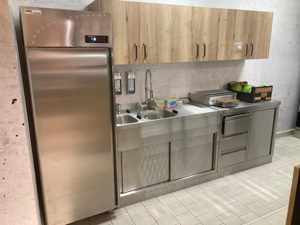 Vorbereitungsraum mit Edelstahlspüle und Kühlschrank