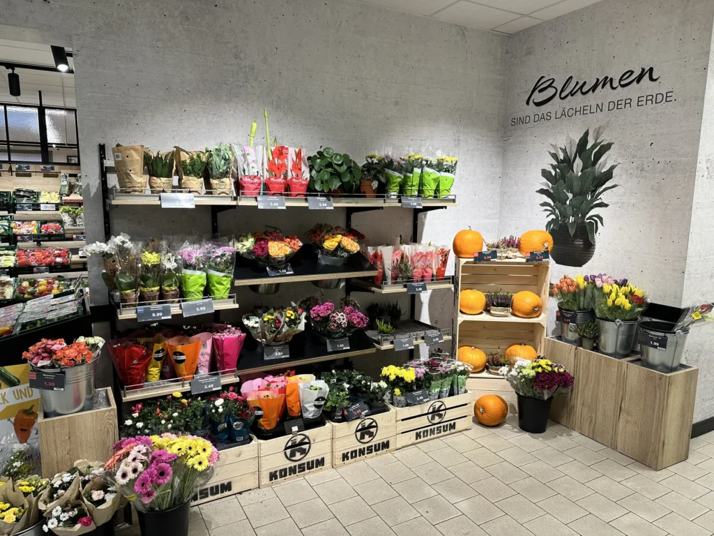 Blumenabteilung mit Regal unter dem Schriftzug »Blumen«