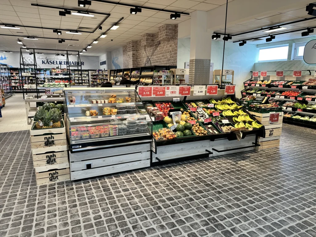 Obst- und Gemüseabteilung mit Kühlinsel und Bedientheke im Hintergrund