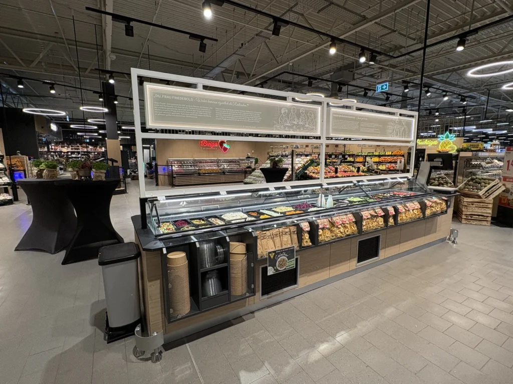 Salatbar mit beleuchtetem Aufsatz in der Obst- und Gemüseabteilung