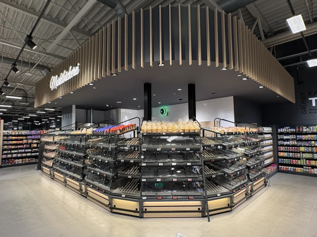 Selbstbedienungsregale der Marktbäckerei unter Holzlamellen